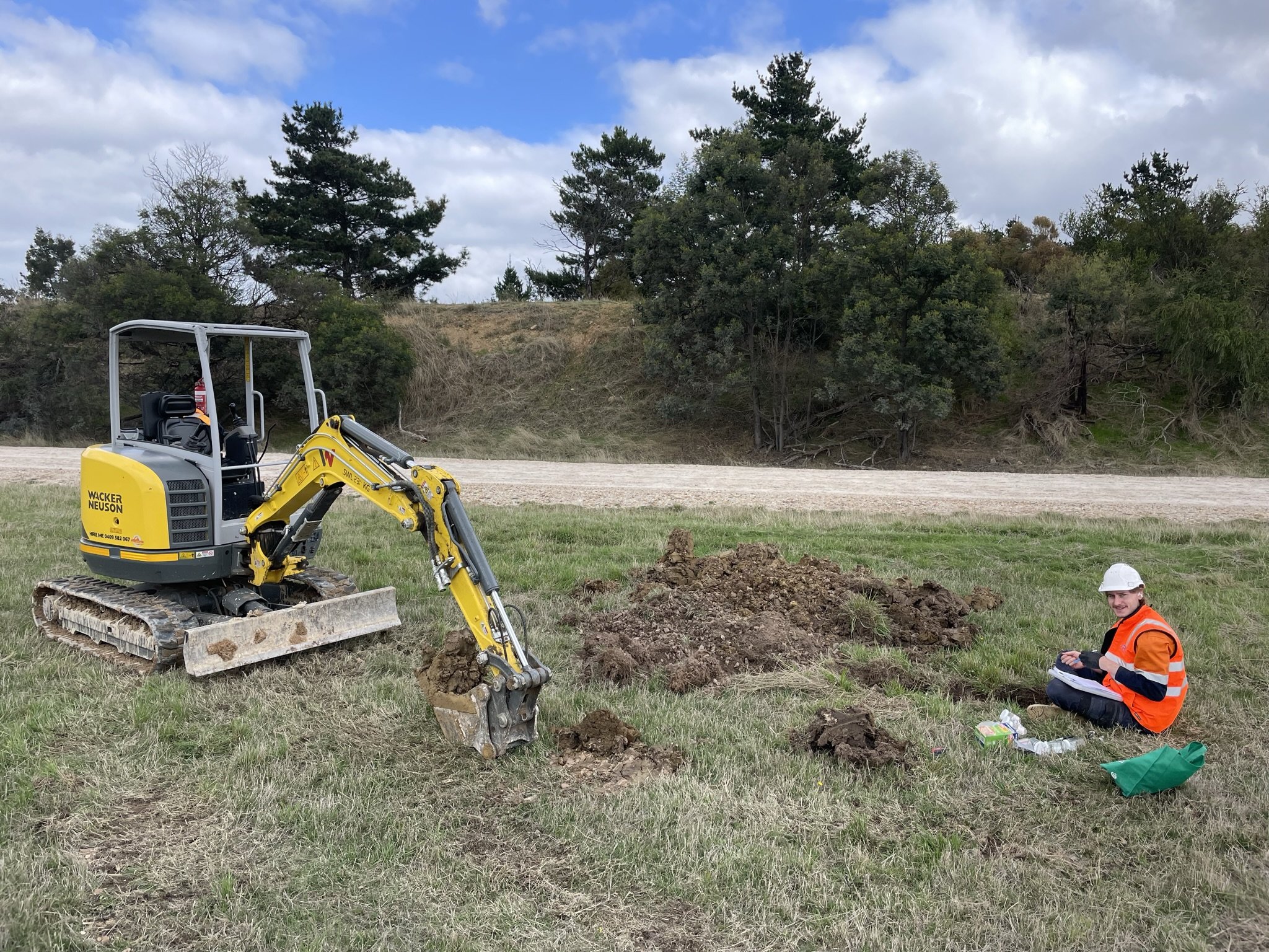 Excavator digging near a person.