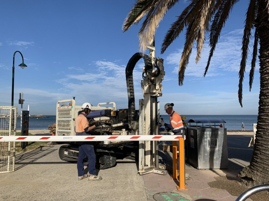Environmental consultant conducting soil sampling on a development site in Victoria. Contaminated land risk assessment near a future residential estate. Groundwater monitoring well installed for EPA audit compliance.
